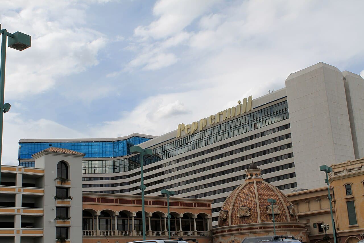 Peppermill Resort Spa Casino's tower in Reno at dusk, its illuminated gold signage above a tiled dome entrance.