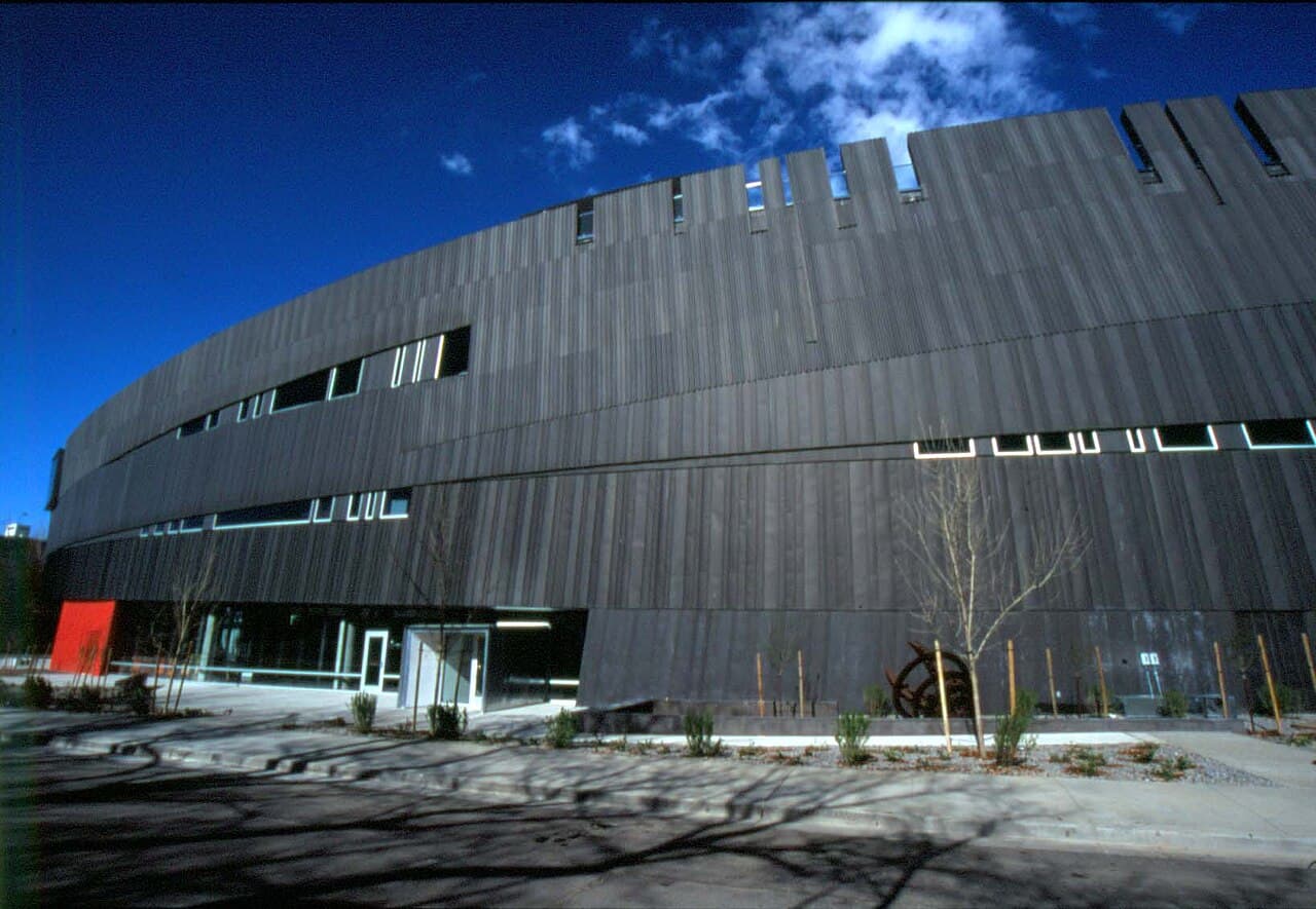 Angular, dark-clad exterior of the Nevada Museum of Art building in downtown Reno against a blue sky.