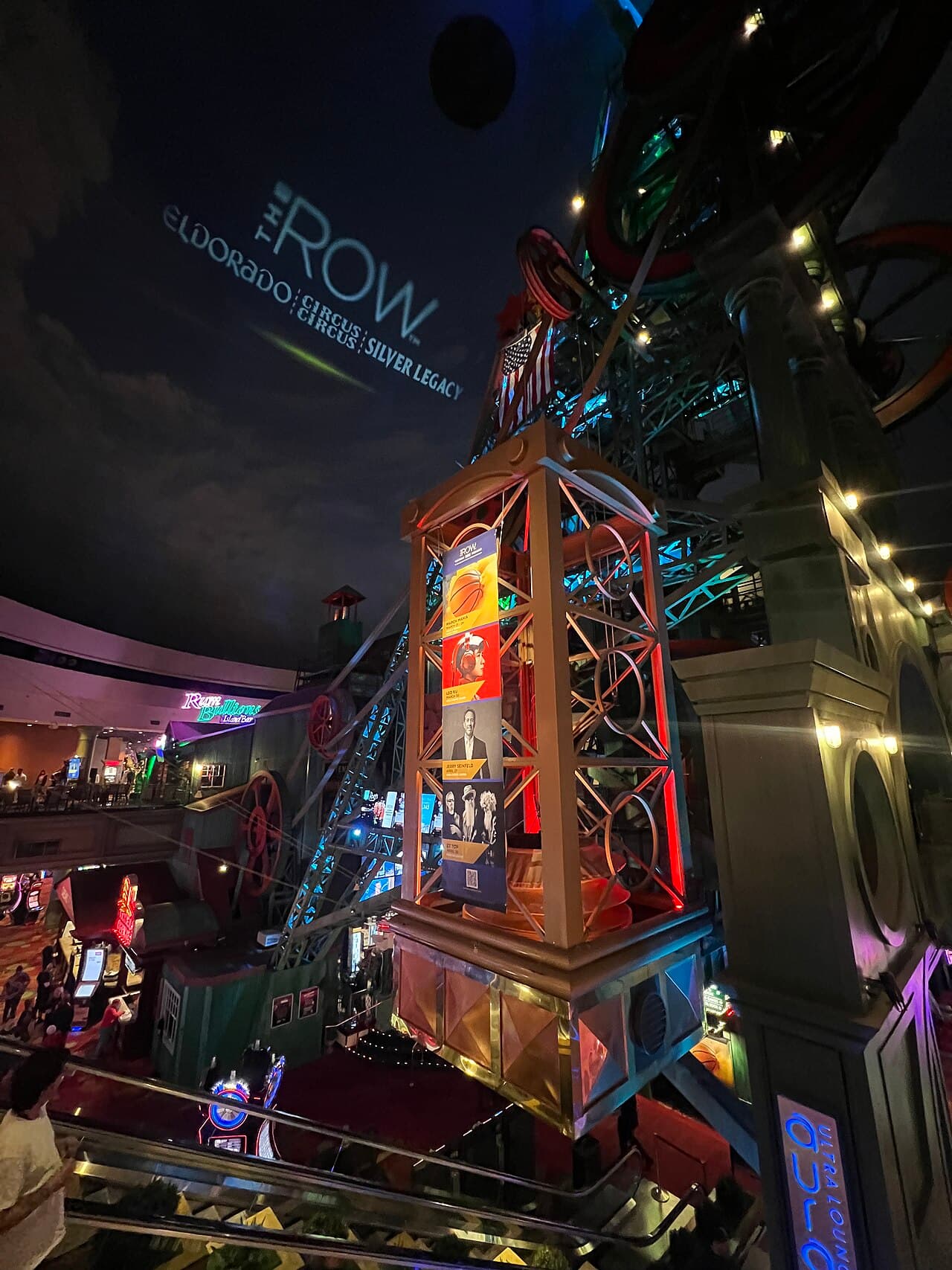 Looking up inside the Silver Legacy Resort Casino's giant dome at the illuminated antique mining-rig sculpture and 'The Row' signage.