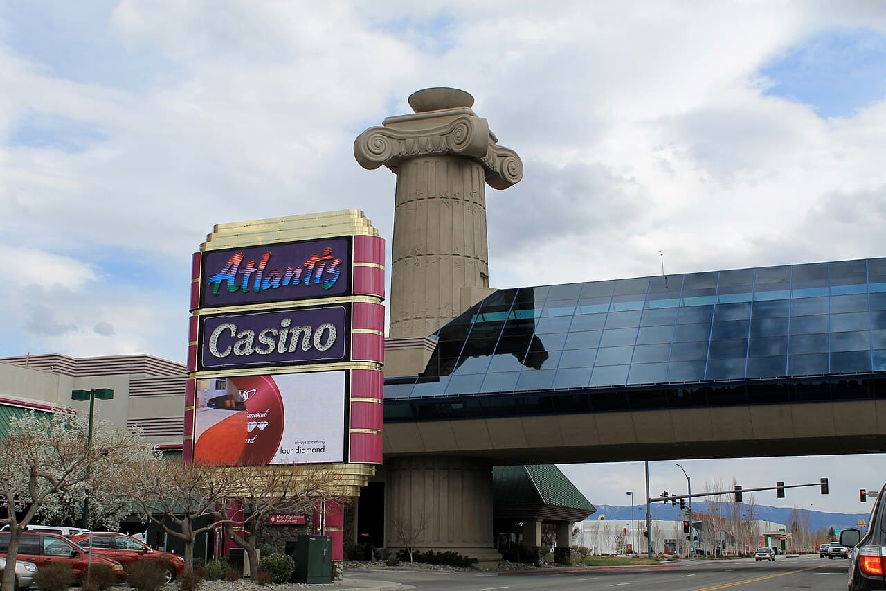 Atlantis Casino Resort Spa's illuminated sign and column beneath the hotel's glass skyway in Reno, Nevada.